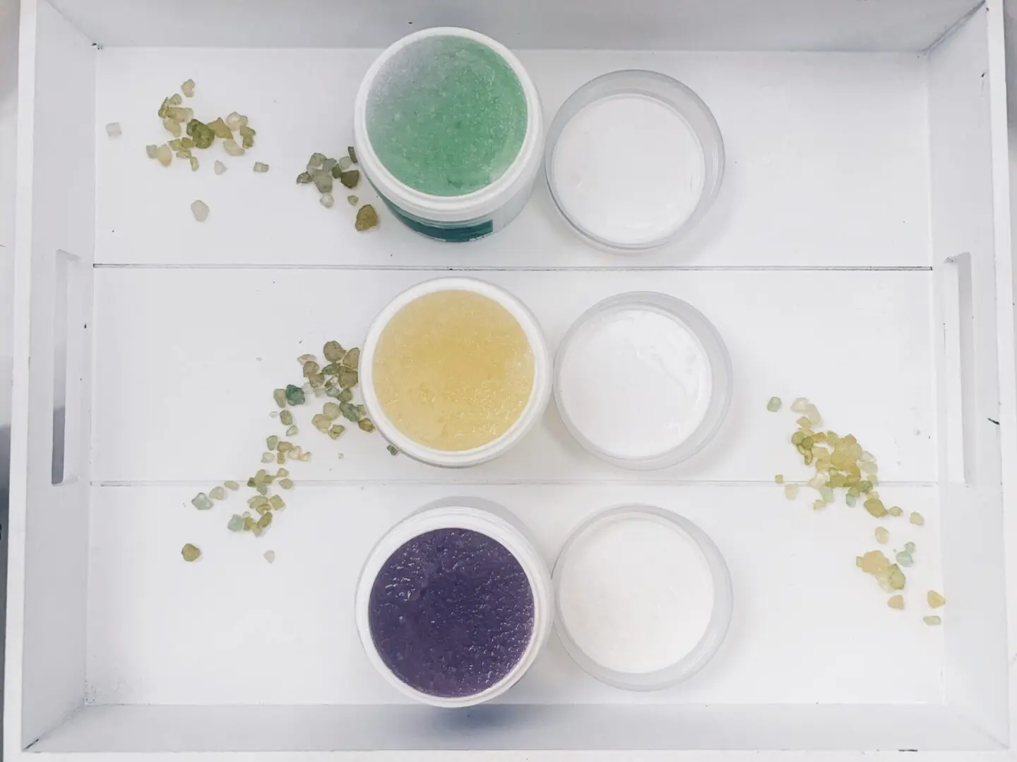 Three cups of different colored liquid sitting on a table.